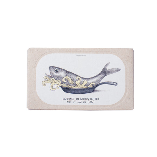 Die Verpackung mit dem Markennamen José Gourmet zeigt eine illustrierte Sardine mit Butterlocken auf einem rechteckigen beigen Hintergrund und hebt „SARDINEN IN AZOREN-BUTTER“ hervor.