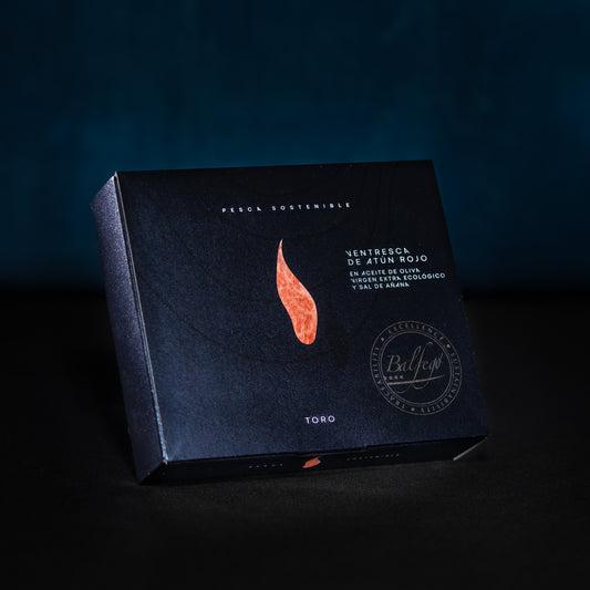 Der BALFEGO-THUNFISCHBAUCH IN OLIVENÖL von Balfego verfügt über eine dunkle Verpackung mit elegantem Design, einschließlich einer roten Fischgrafik und einem spanischen Text, der Balfegos Engagement für nachhaltigen Thunfisch (nachhaltiger Fang) betont.