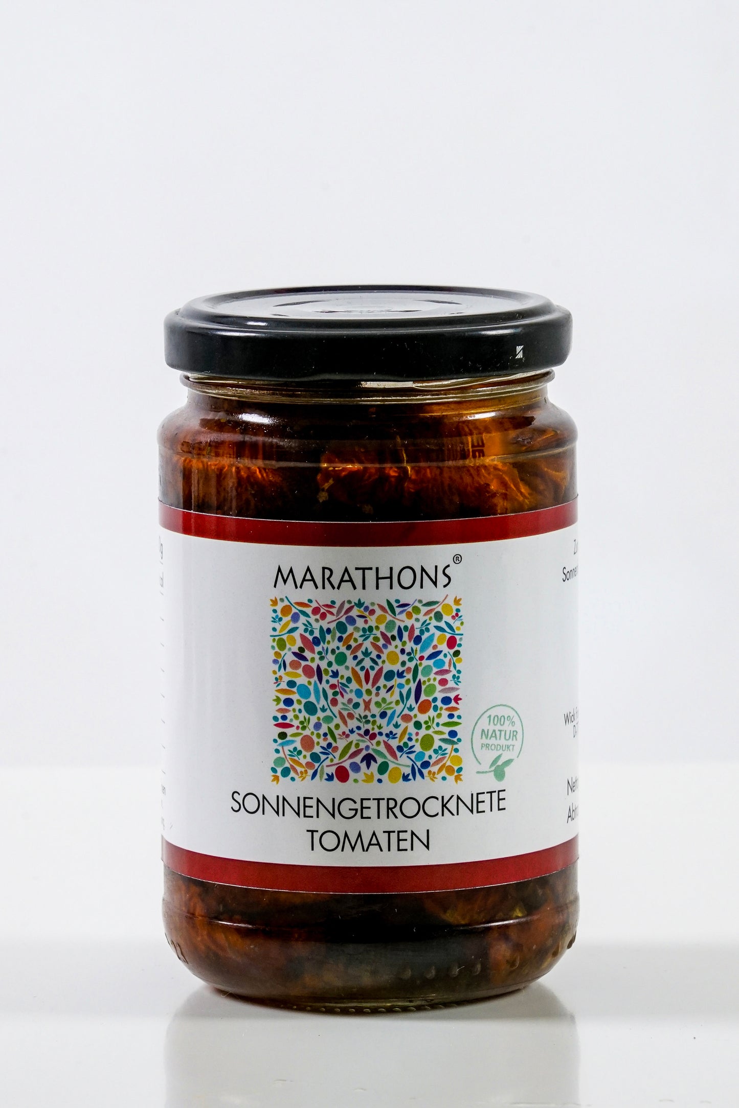 Glas mit SONNENGETROCKNETEN GRIECHISCHEN TOMATEN von Wick Food mit duftendem Oregano, mit einem farbenfrohen Etikett im griechischen Stil und einem eleganten schwarzen Deckel.